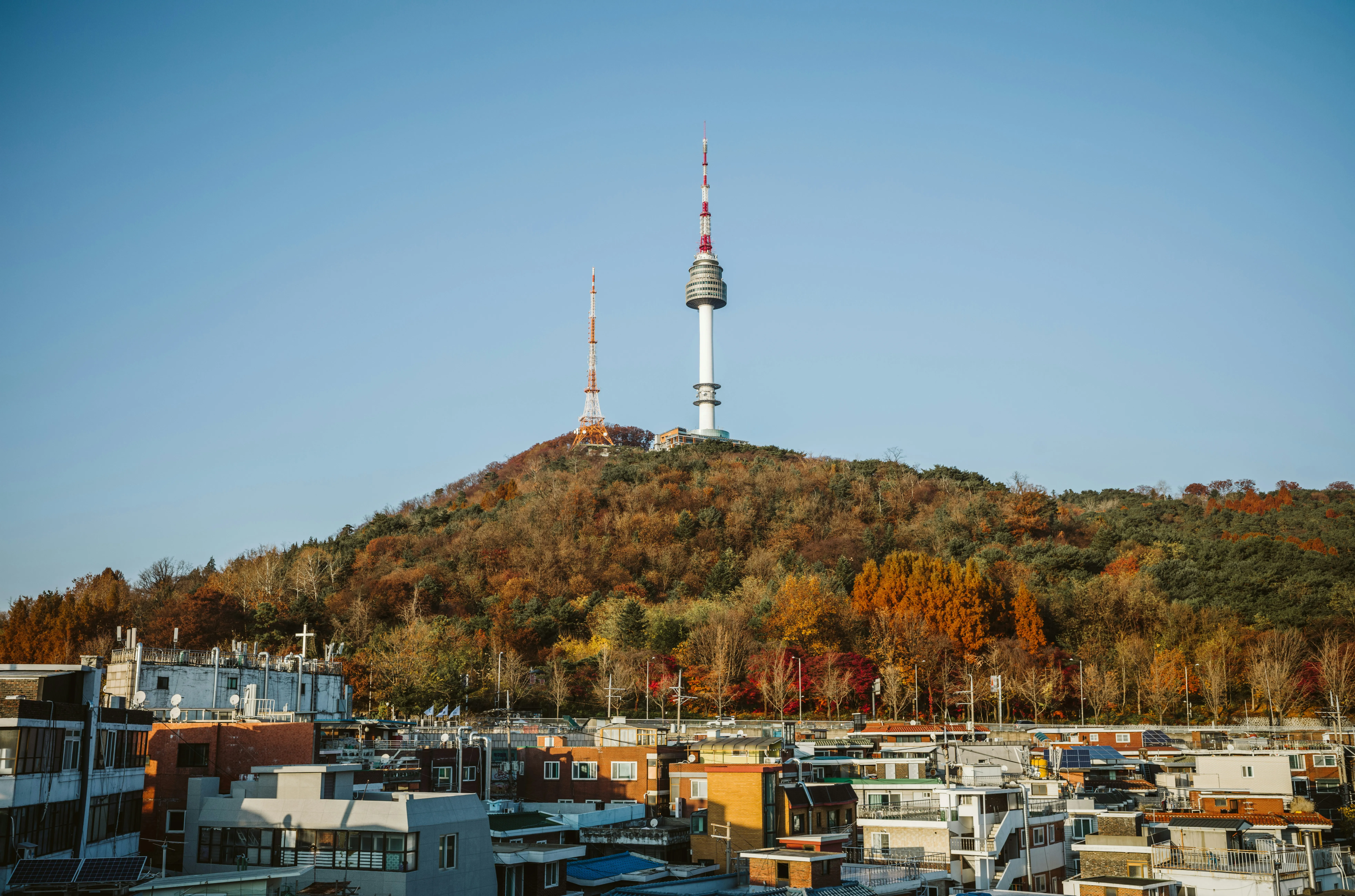 La tour Namsan sur sa colline boisée aux couleurs d'automne, au-dessus des toits de Séoul
