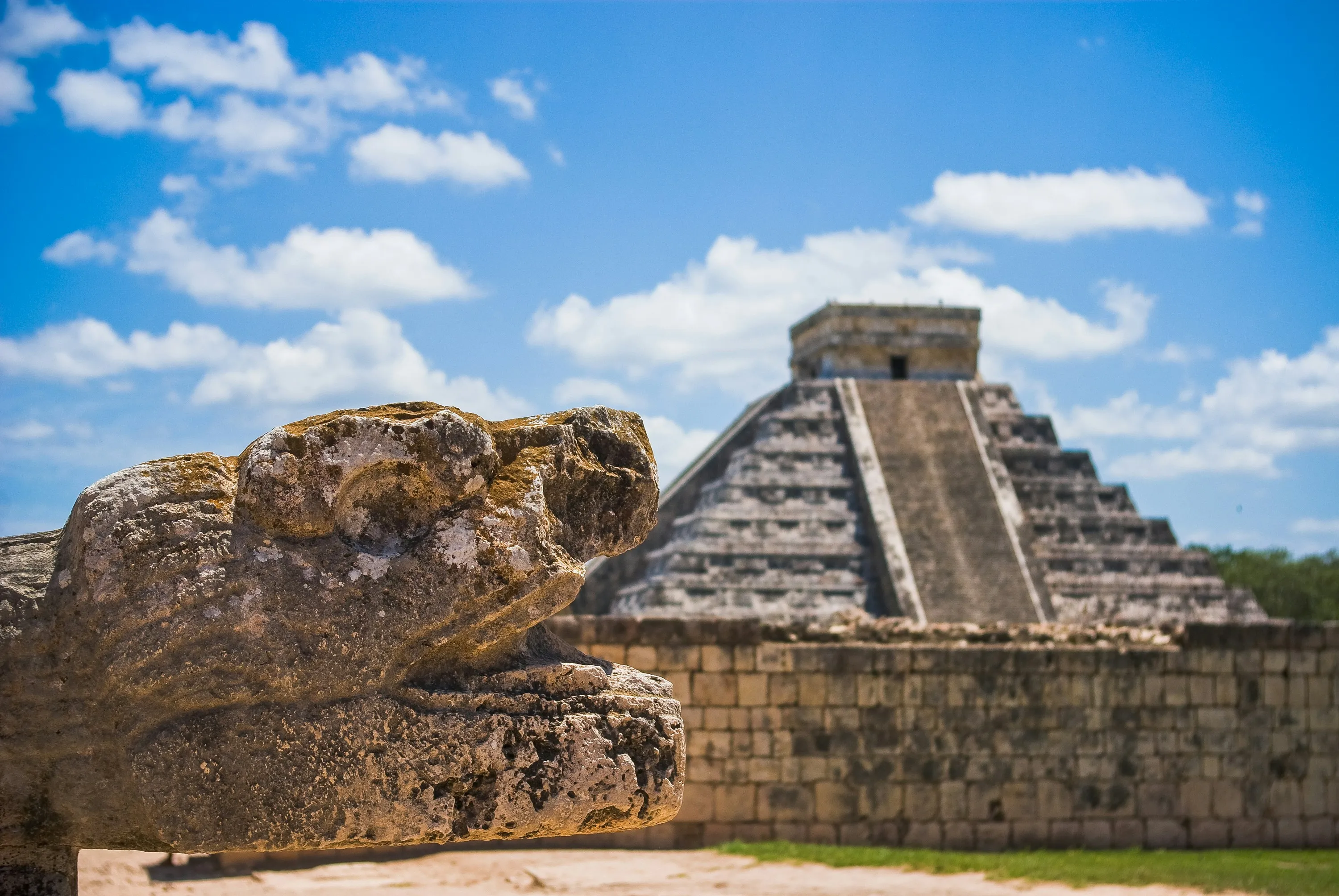 Tête de serpent à plumes sculptée devant la pyramide de Kukulcán, à Chichén Itzá