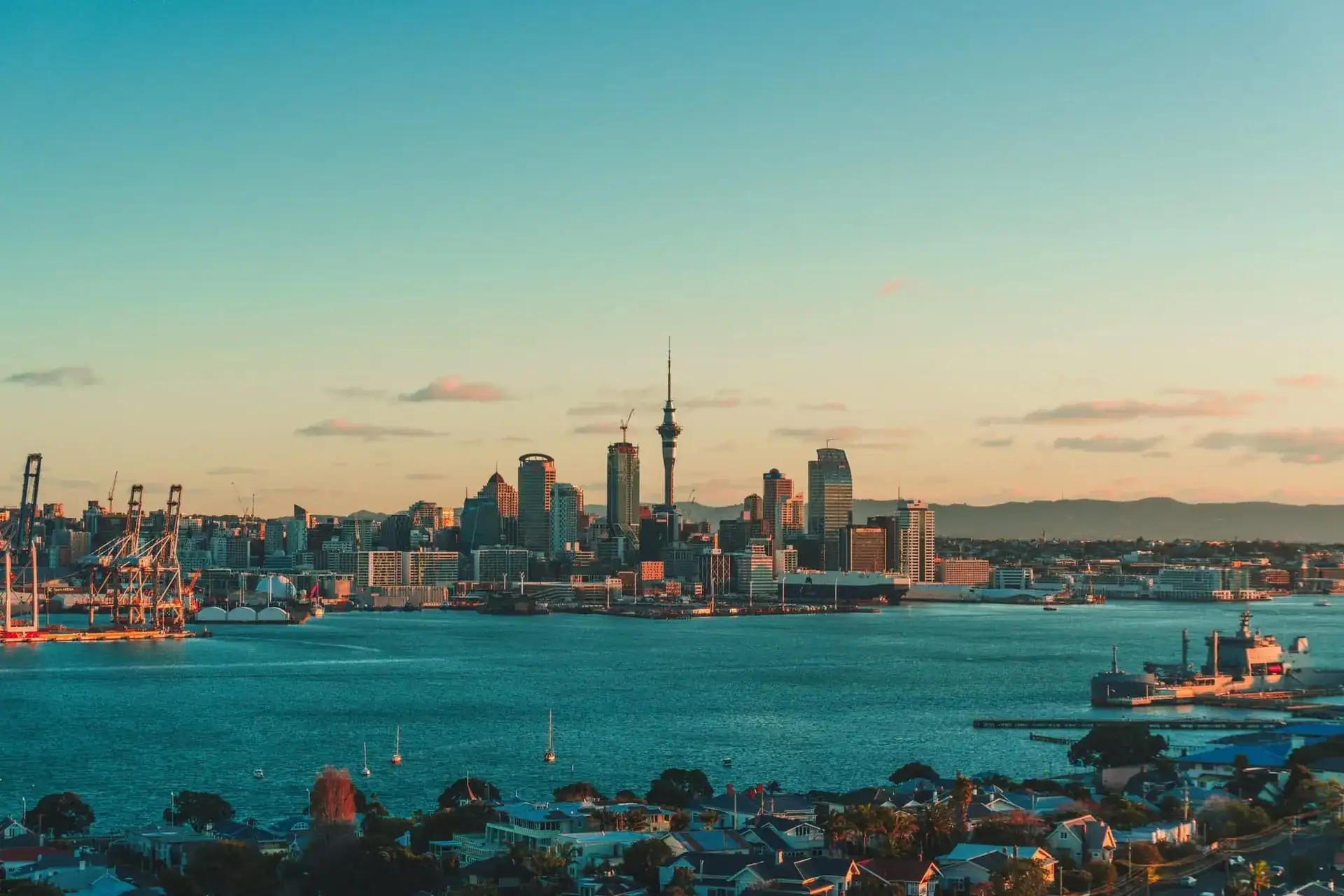 La skyline d'Auckland et la Sky Tower au coucher du soleil, voiliers ancrés dans la baie