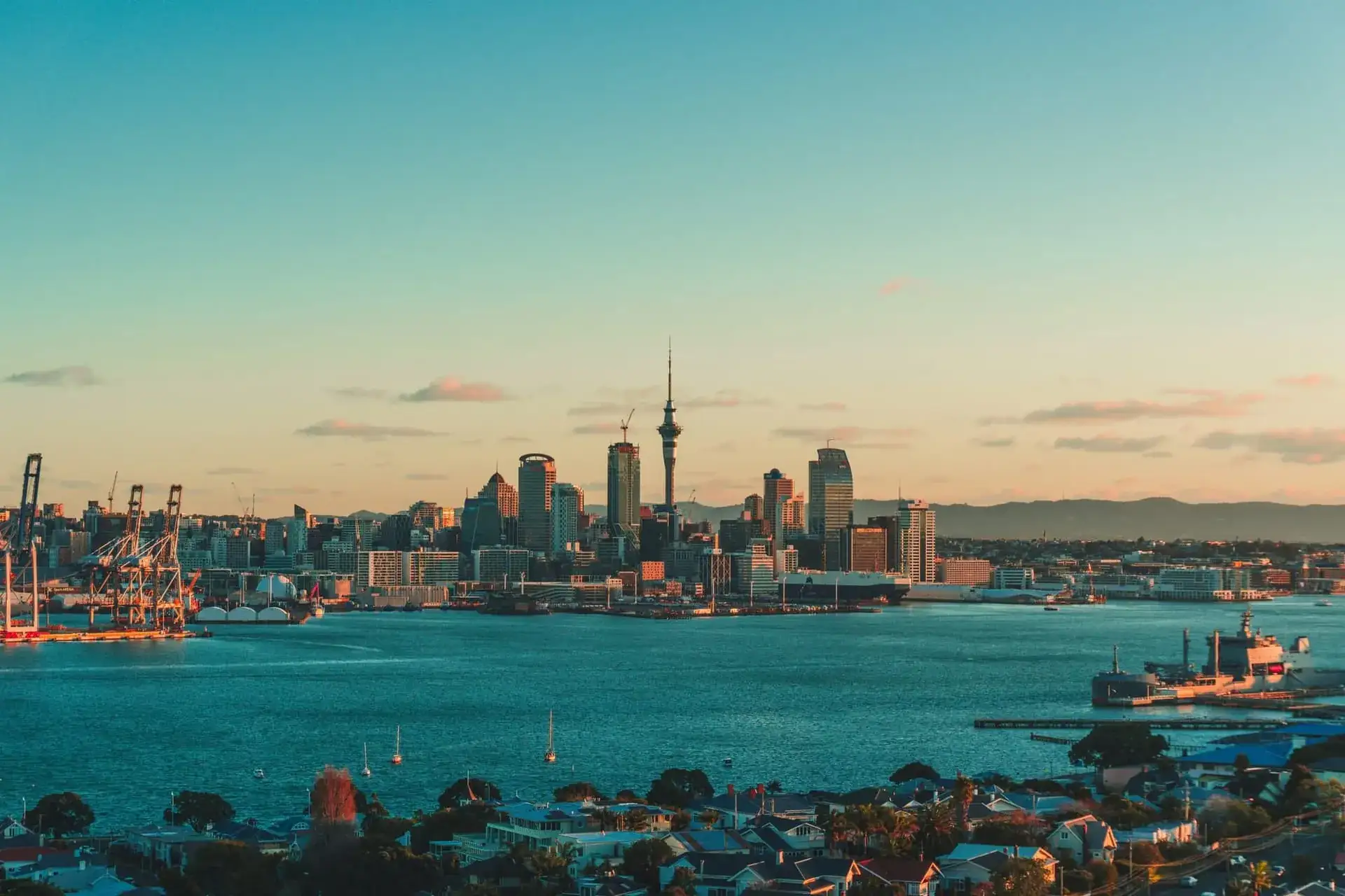 La skyline d'Auckland et la Sky Tower au coucher du soleil, voiliers ancrés dans la baie