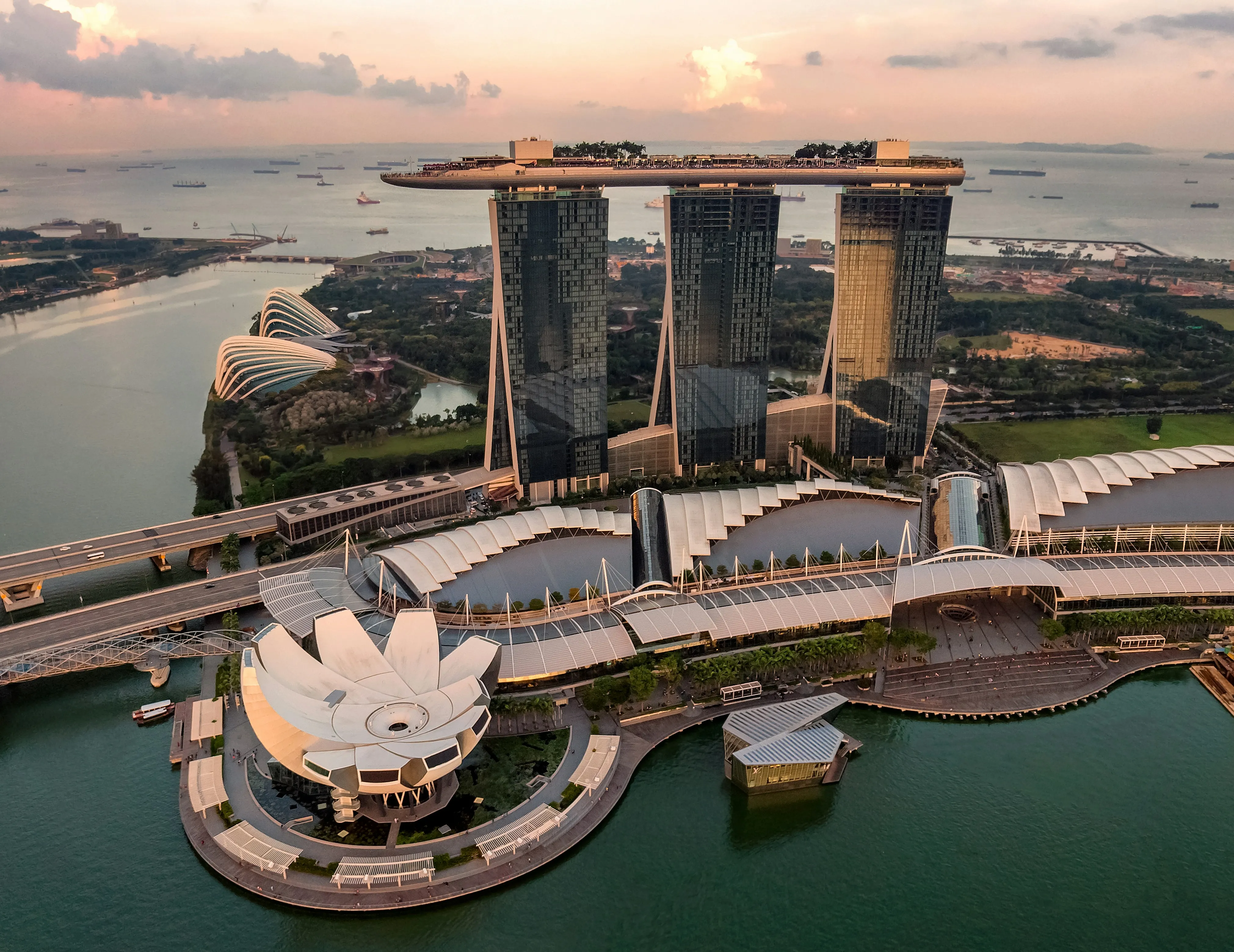 Vue aérienne de Marina Bay au crépuscule, les trois tours du Marina Bay Sands et le musée ArtScience en fleur de lotus